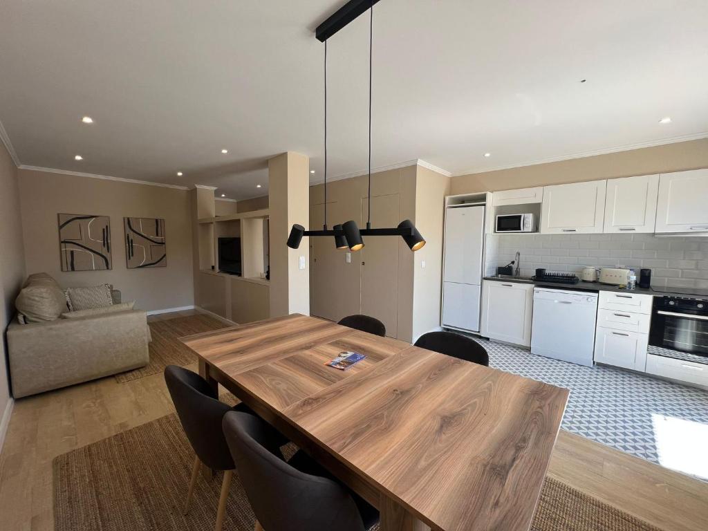波尔图Oporto Near Family Apartments的厨房以及带木桌和椅子的用餐室。