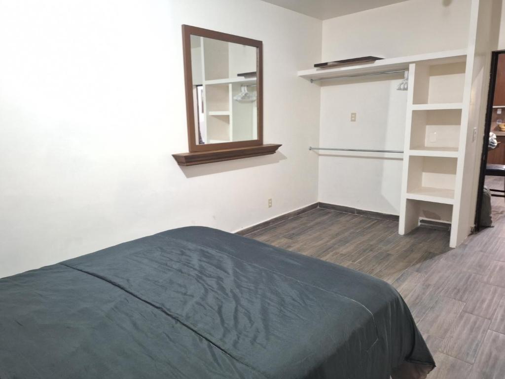 埃莫西约MercedesHouse的一间卧室配有一张床、镜子和一个衣柜