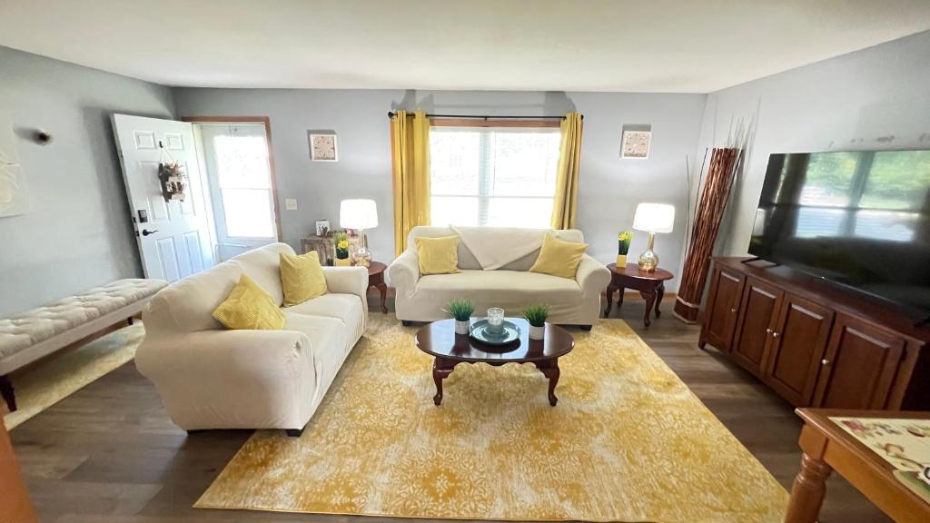 密尔沃基Luxx Guest House的客厅配有2张白色沙发和1张咖啡桌