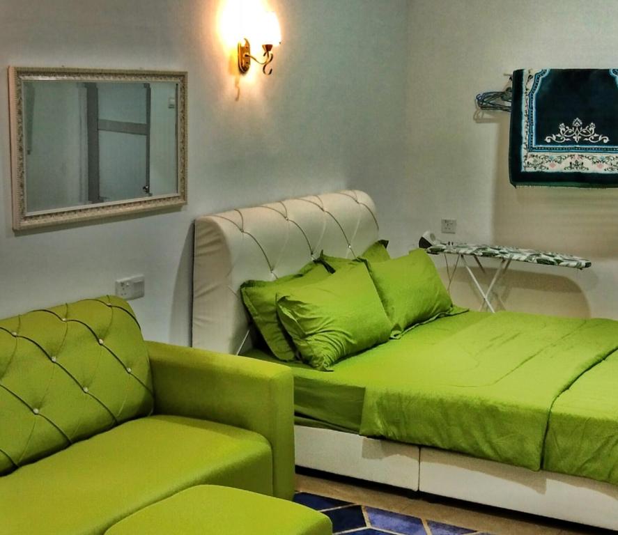 波德申PD ROOM STAY的一张绿色的床和一个沙发