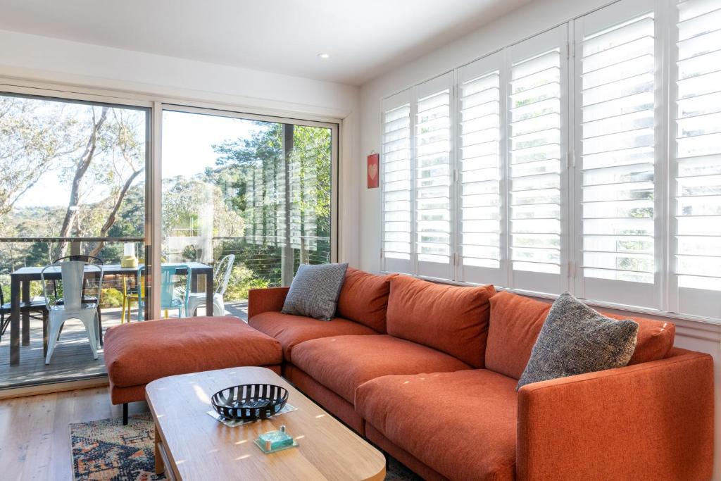 肯图巴Katoomba Falls Cottage的客厅配有橙色沙发和桌子