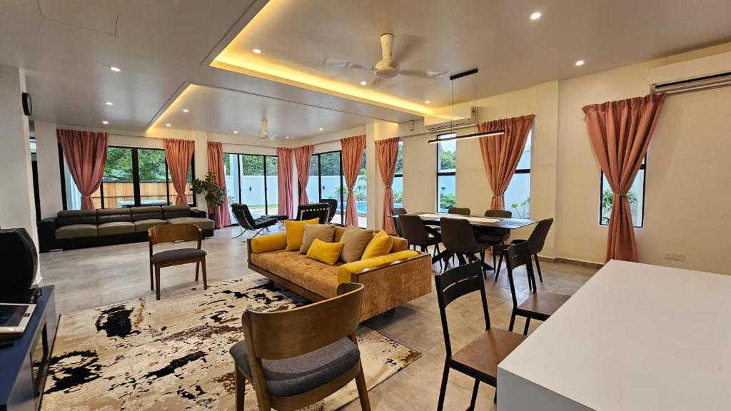 瓜埠Rumah Amaan的客厅配有沙发和桌椅