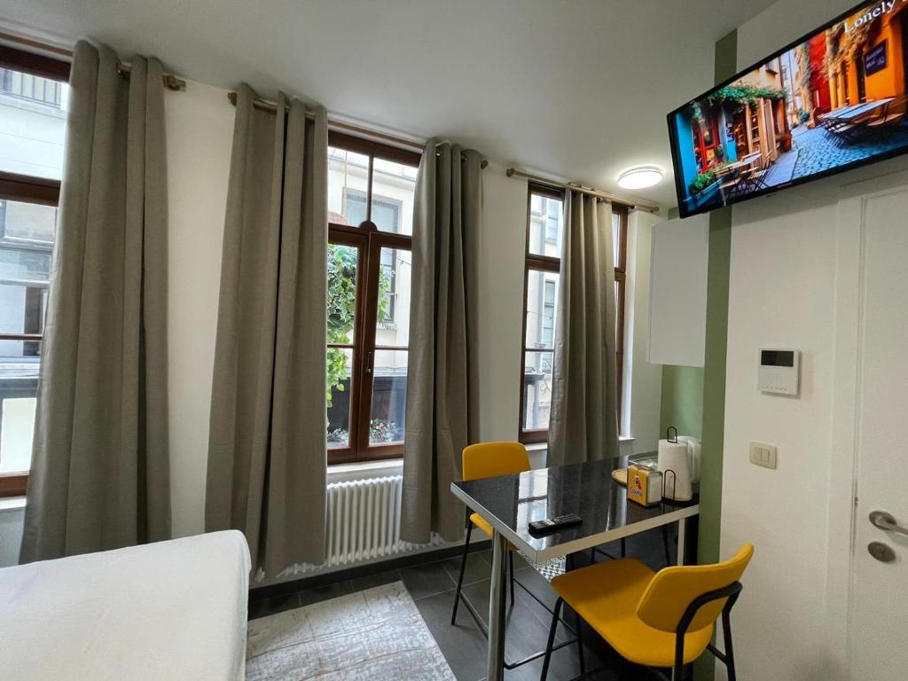 布鲁塞尔Apartament的客房设有桌子、椅子和窗户。
