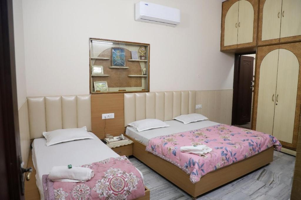 阿姆利则Rk Lodge的一间卧室配有两张床和镜子