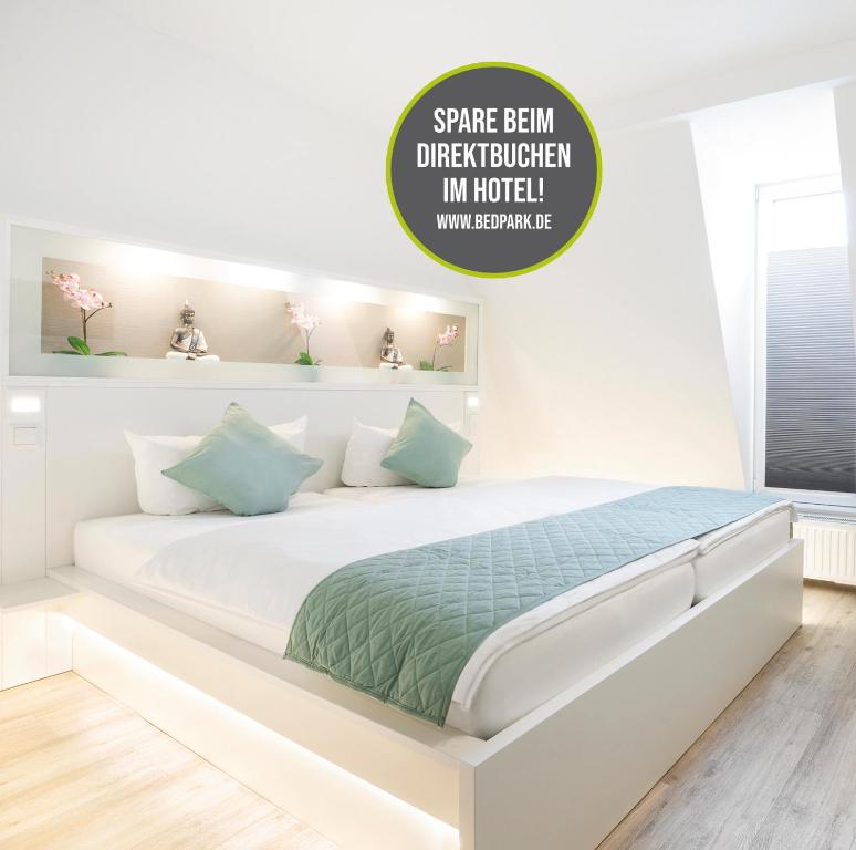 汉堡斯特灵根贝德帕克酒店的白色卧室配有带绿色床单的大型白色床
