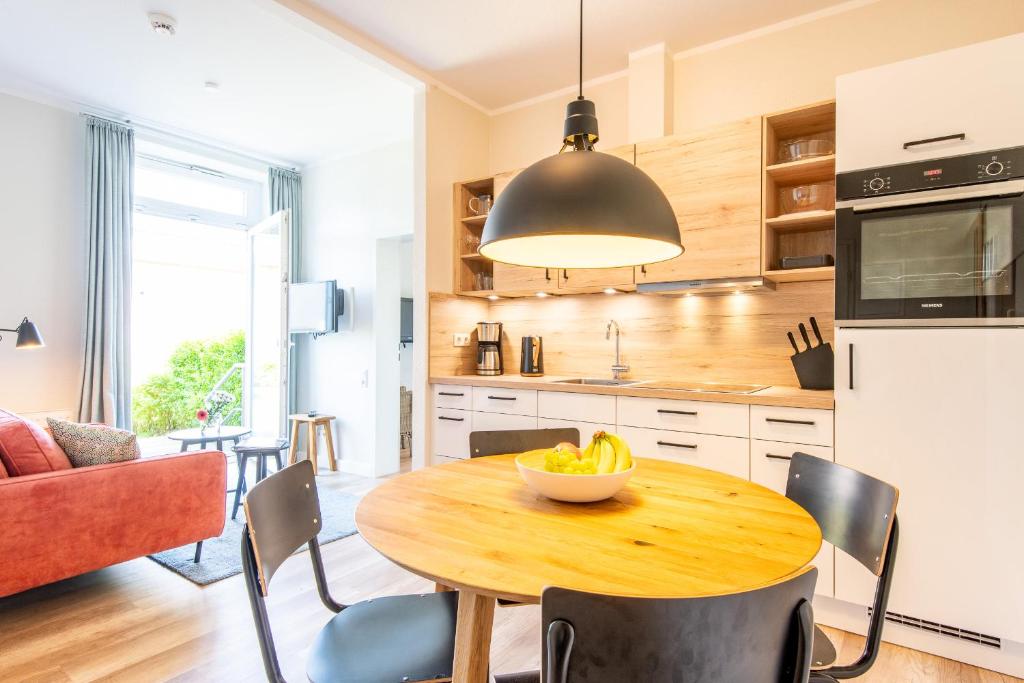 兰图姆Steger-Hüs Wohnung 02的厨房配有木桌,上面放着一碗水果