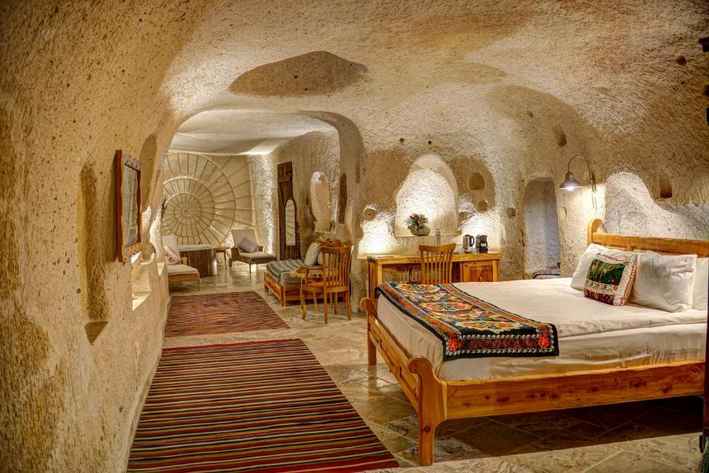 乌奇希萨尔Petra Inn Cappadocia的石头间内一间卧室,配有一张床