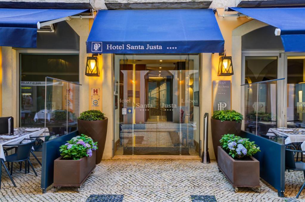 里斯本圣塔胡斯塔酒店的一间设有蓝色遮阳篷、桌子和鲜花的餐厅