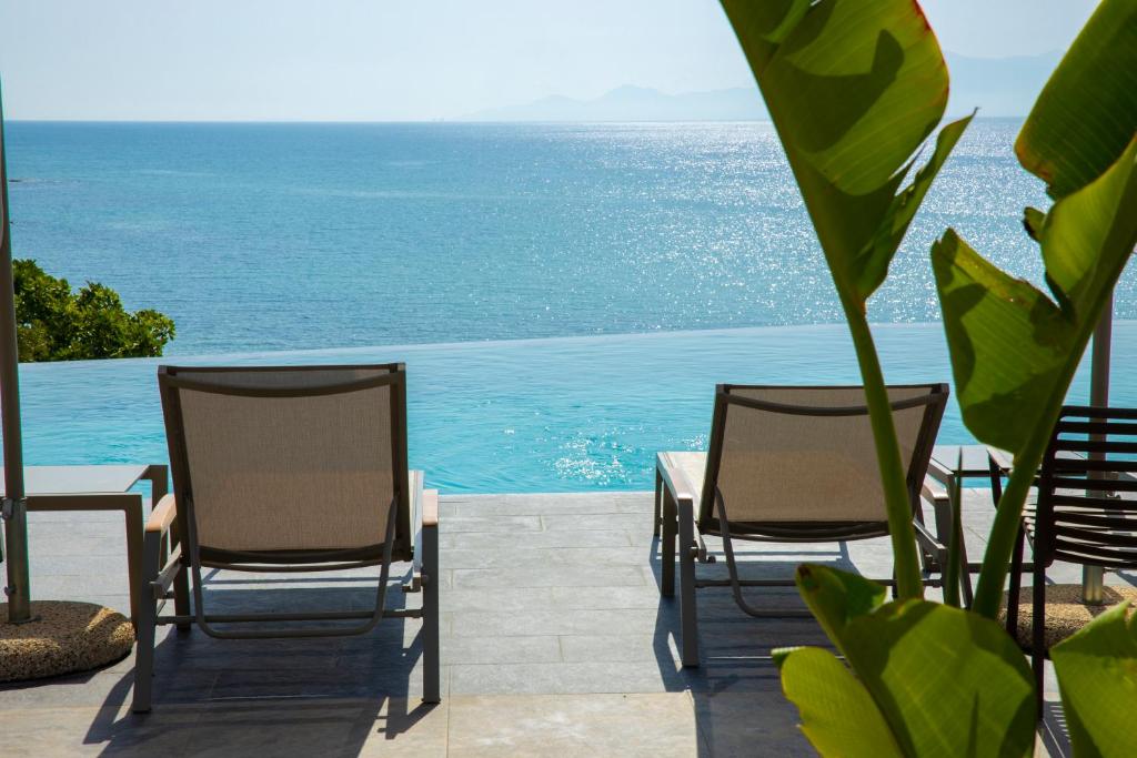 ElaiokhórionAnasa Luxury Resort的两把椅子和一张桌子,背靠大海