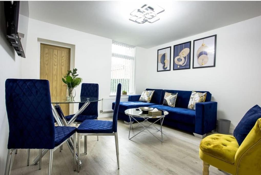 特伦特河畔斯托克Cosy Cruise Cribs Ltd的客厅配有蓝色的沙发和玻璃桌
