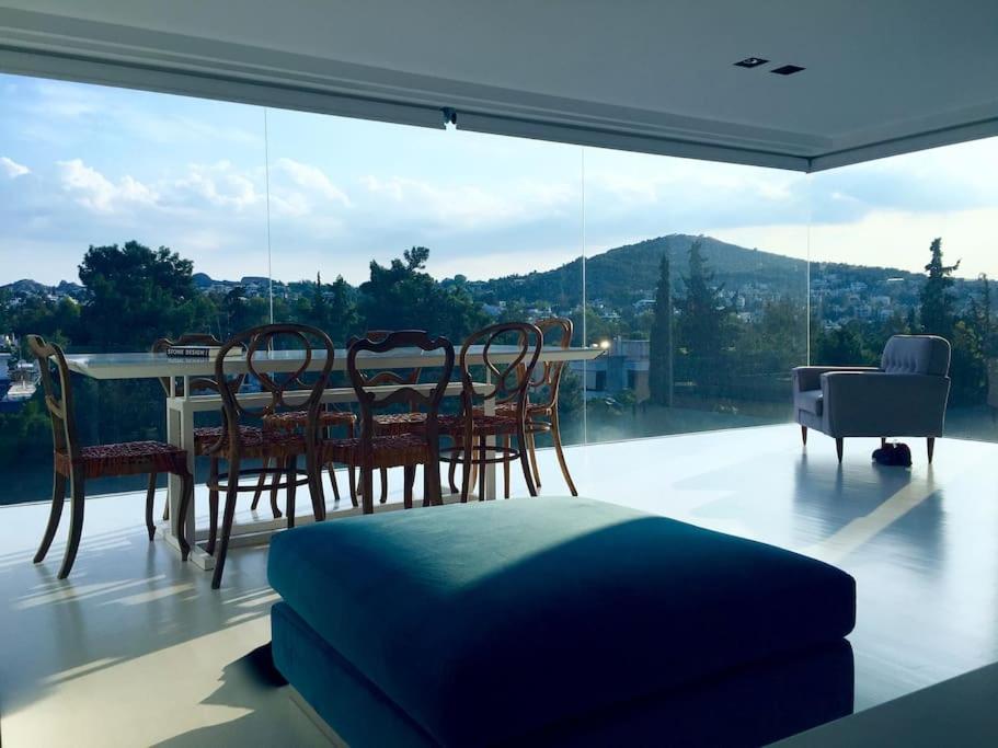 雅典luxury ph private pool+roof garden的一间带桌椅和大窗户的用餐室