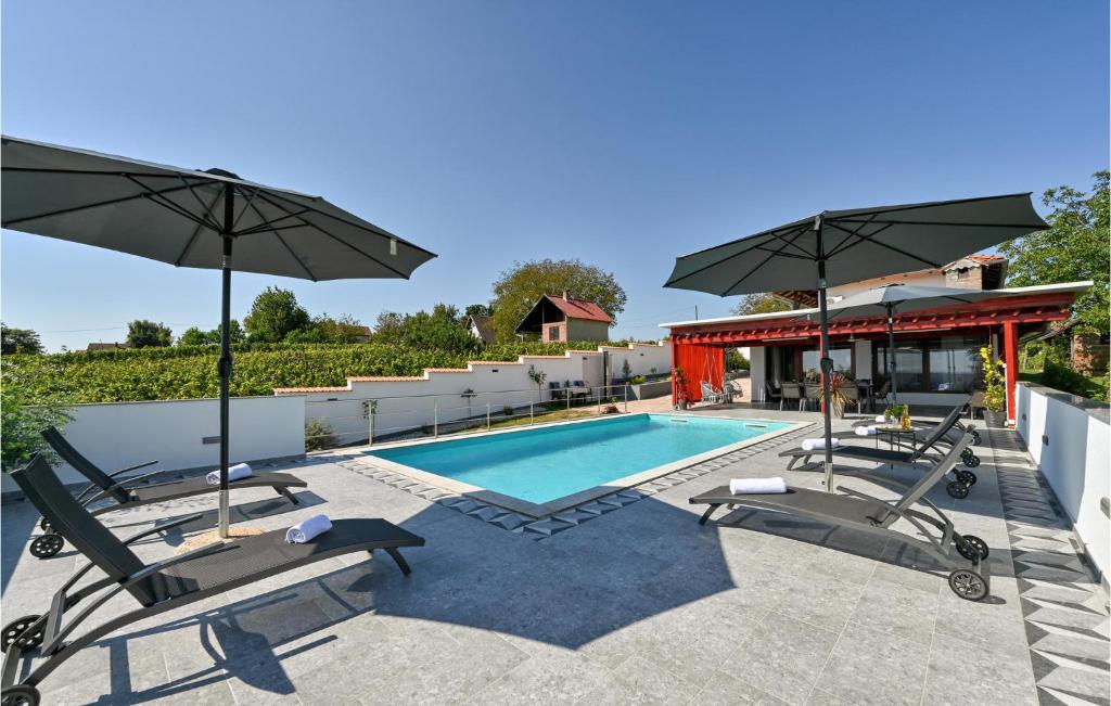 Gorgeous Home In Sedlarica With Heated Swimming Pool的一个带椅子和遮阳伞的游泳池