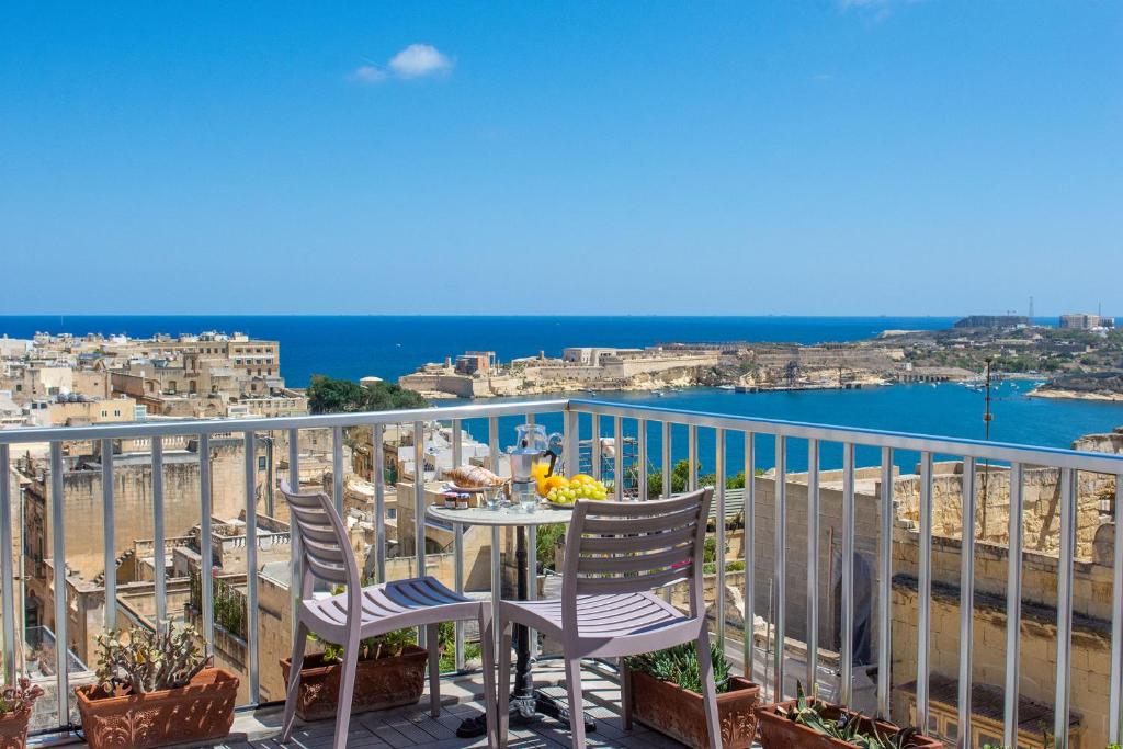 瓦莱塔Valletta Apartments 19的阳台配有桌椅,享有海滩美景。