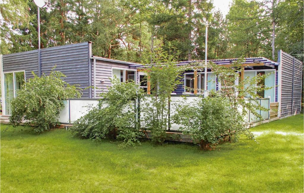 ØksenmølleNice Home In Ebeltoft With Kitchen的一座小房子,位于一个灌木丛的院子内