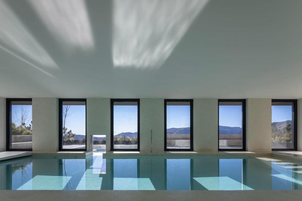 曼泰加什Casa de São Lourenço - Burel Mountain Hotels的一座带窗户的游泳池,位于一座建筑中