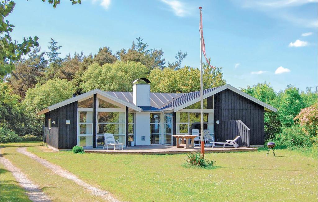 埃贝尔托夫特Amazing Home In Ebeltoft With Sauna的院子里带野餐桌的黑色小房子