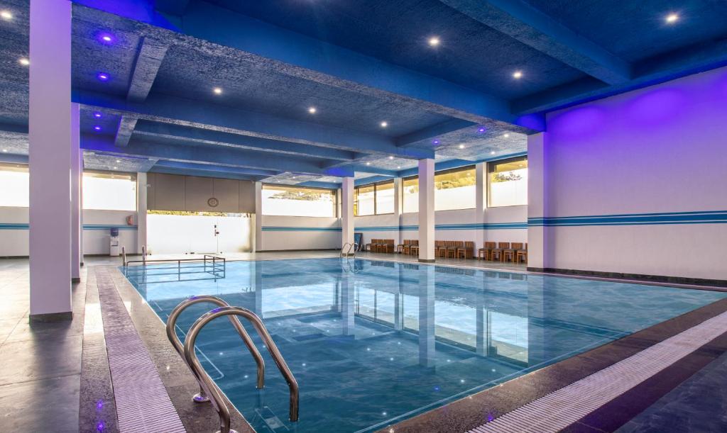 马迪凯里Treebo Trend The Rove的一座大型室内游泳池,在大楼内拥有蓝色的灯光