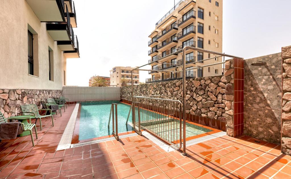 埃拉特HOTEL SHOSHANA的建筑物一侧的游泳池