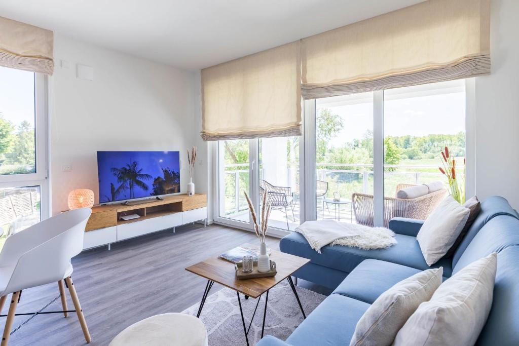 博尔滕哈根Weiße Villen "das Meeresloft"的客厅配有蓝色的沙发和电视