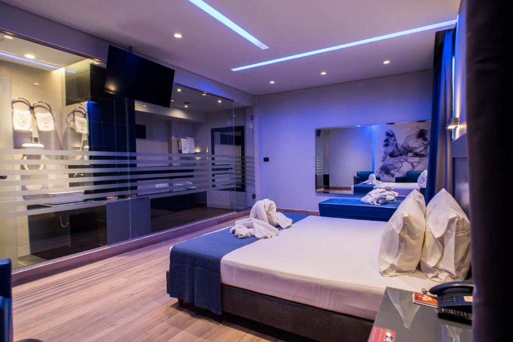 雅典派内斯酒店的一间卧室配有一张床,并在一间客房内配有电视。