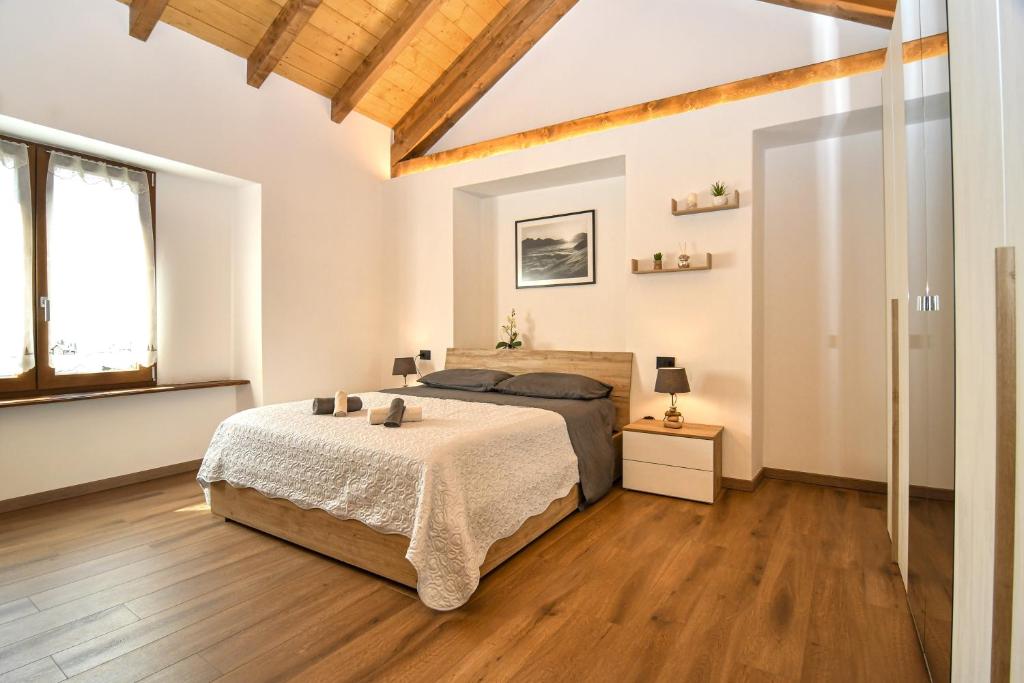 马莱斯科La Terrazza的一间卧室设有一张大床,铺有木地板