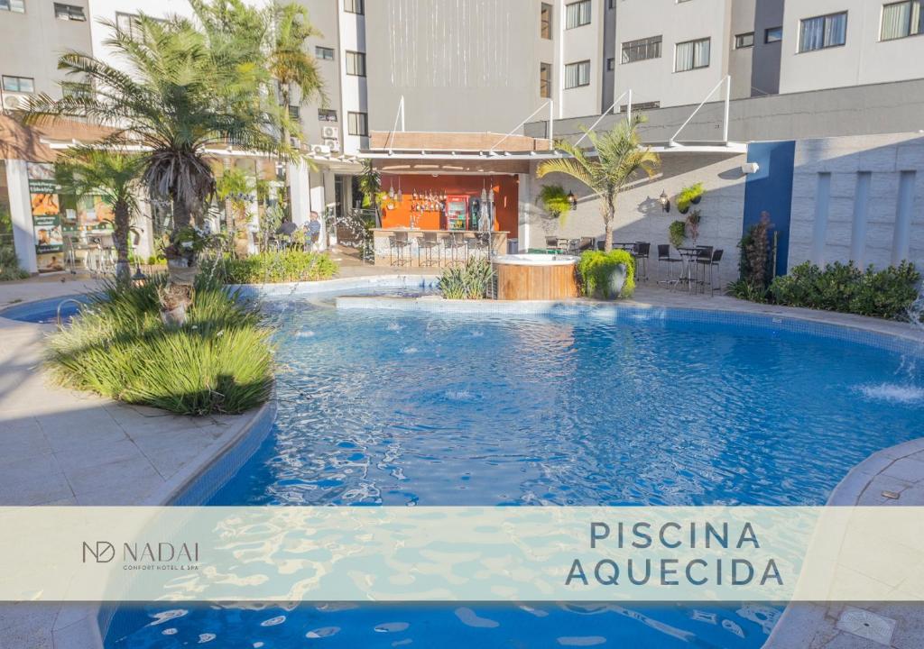 伊瓜苏纳达依便捷酒店及水疗中心的一座建筑物中央的游泳池