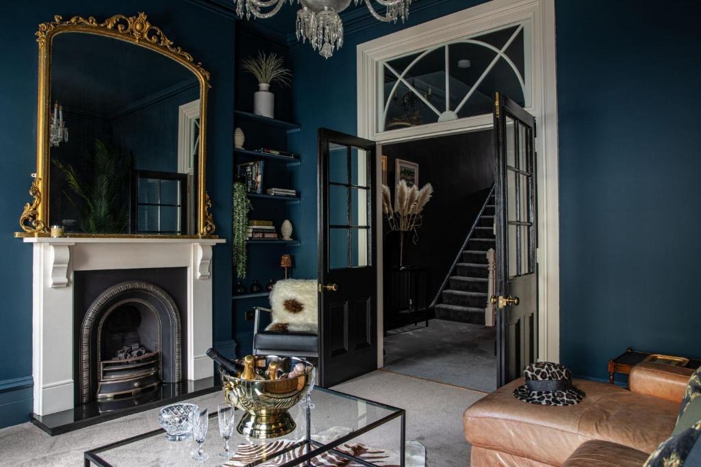 谢伯恩The Townhouse Sherborne的客厅设有蓝色的墙壁和镜子