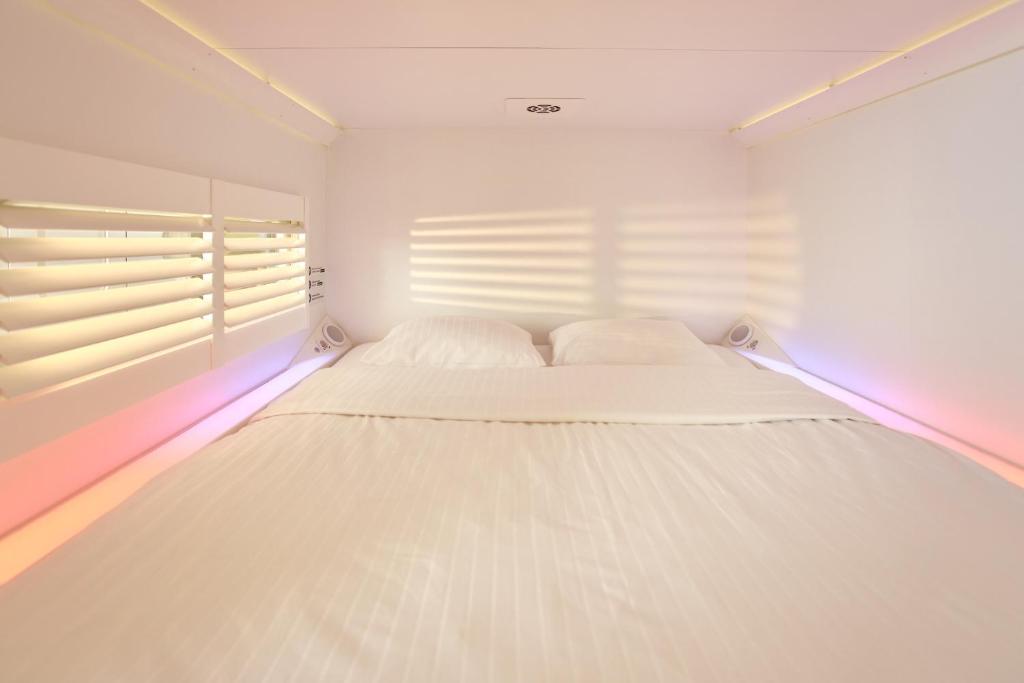 鹿特丹鹿特丹市中心旅舍的窗户客房内的一张白色床