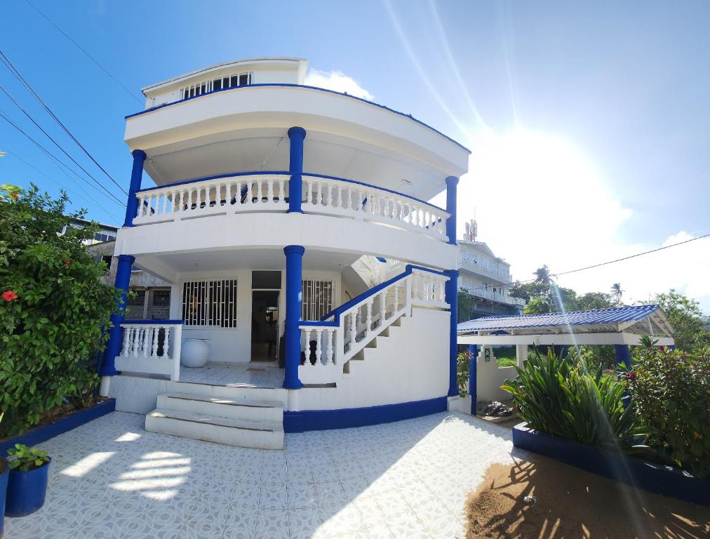 圣安德烈斯Apartamentos SurOeste的白色的大房子,有蓝色的柱子和楼梯