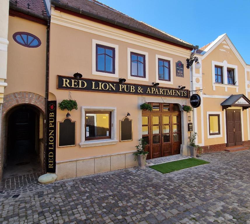 圣安德烈Red Lion Pub & Apartments Szentendre的一座拥有红狮酒吧和公寓的建筑