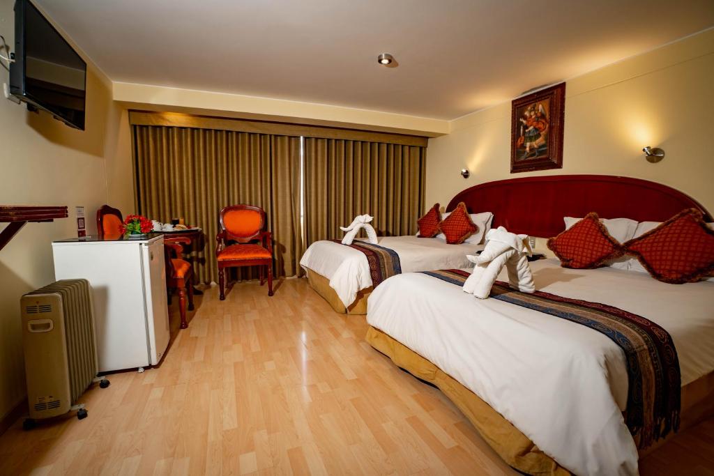 库斯科Hotel Agustos Cusco的酒店客房,配有两张床和椅子