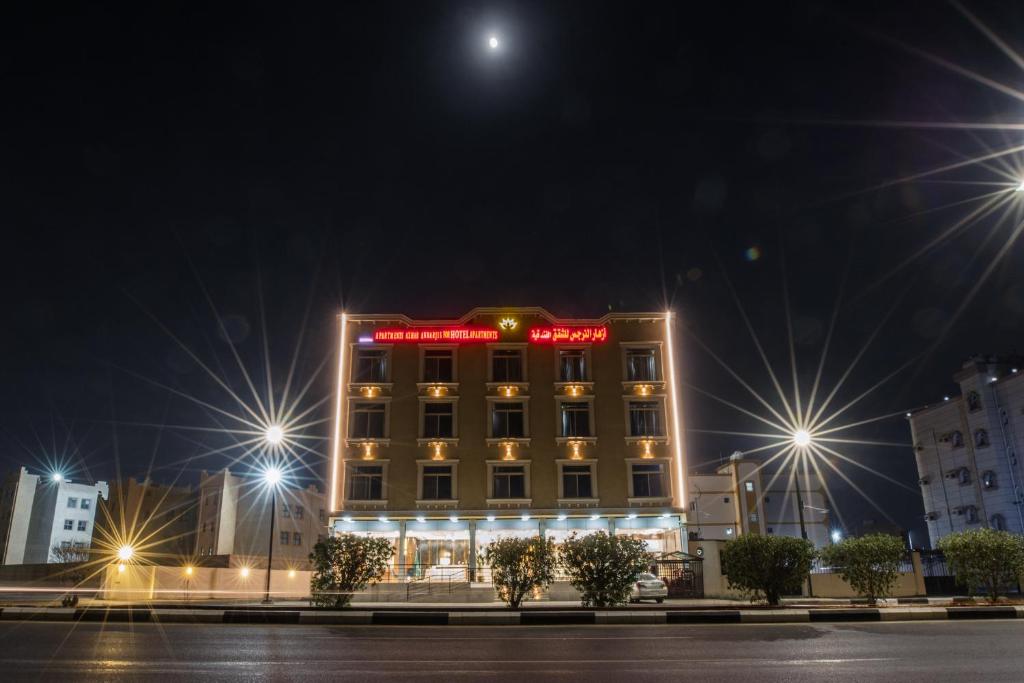 Umm al Khashabأزهار النرجس للشقق الفندقية的一家晚上在上面标有标志的酒店
