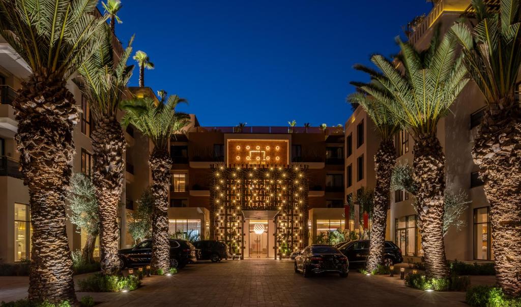 马拉喀什Pestana CR7 Marrakech的一座楼前有棕榈树的酒店