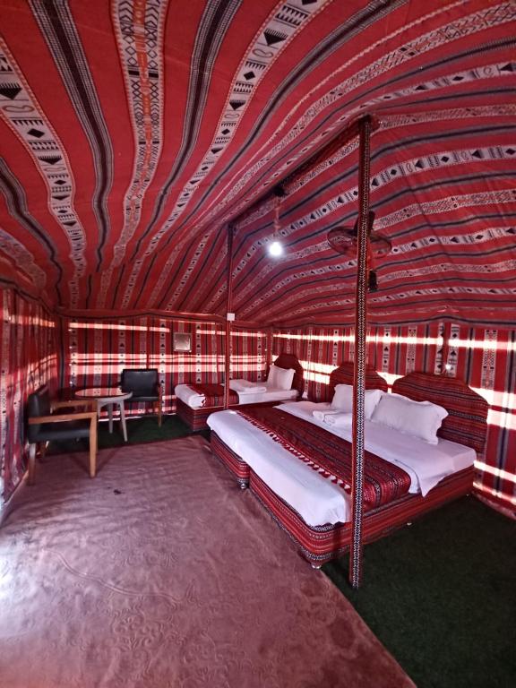 BadīyahSunrise Desert Local Private Camp的一间卧室设有两张床和红色天花板