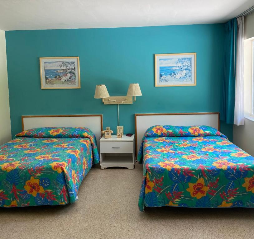 迈阿密Silver Sands Beach Resort的蓝色墙壁客房的两张床