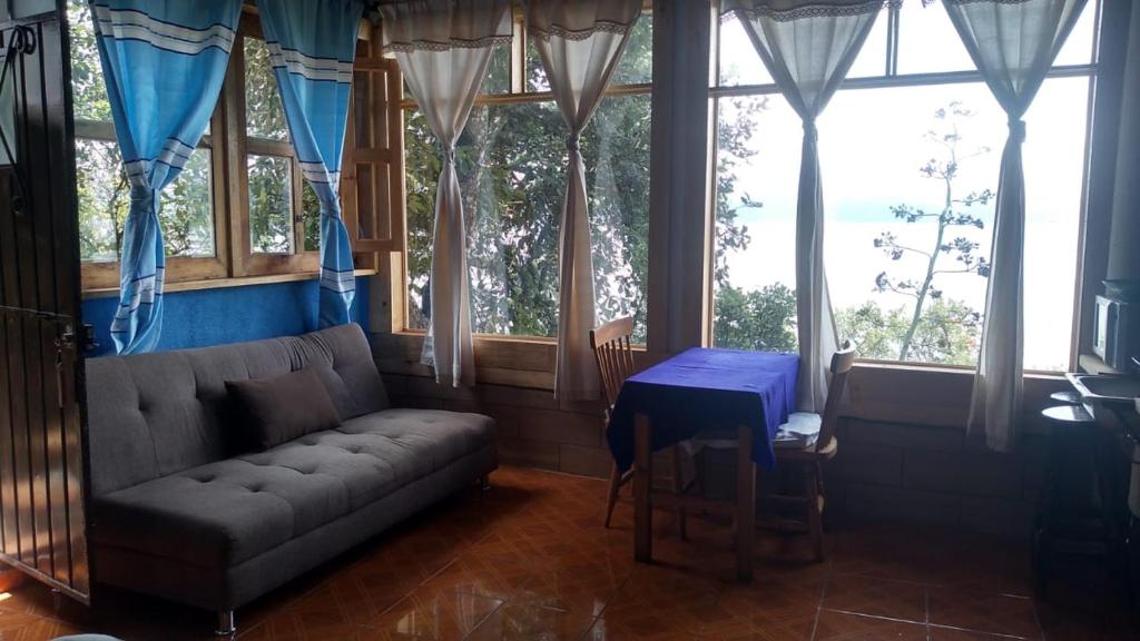 兹拉胡恩Cabañas AURORA的带沙发、桌子和窗户的客厅
