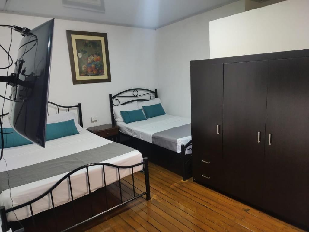 马尼萨莱斯HOTEL GIRASOLES的一间带两张床和梳妆台的卧室