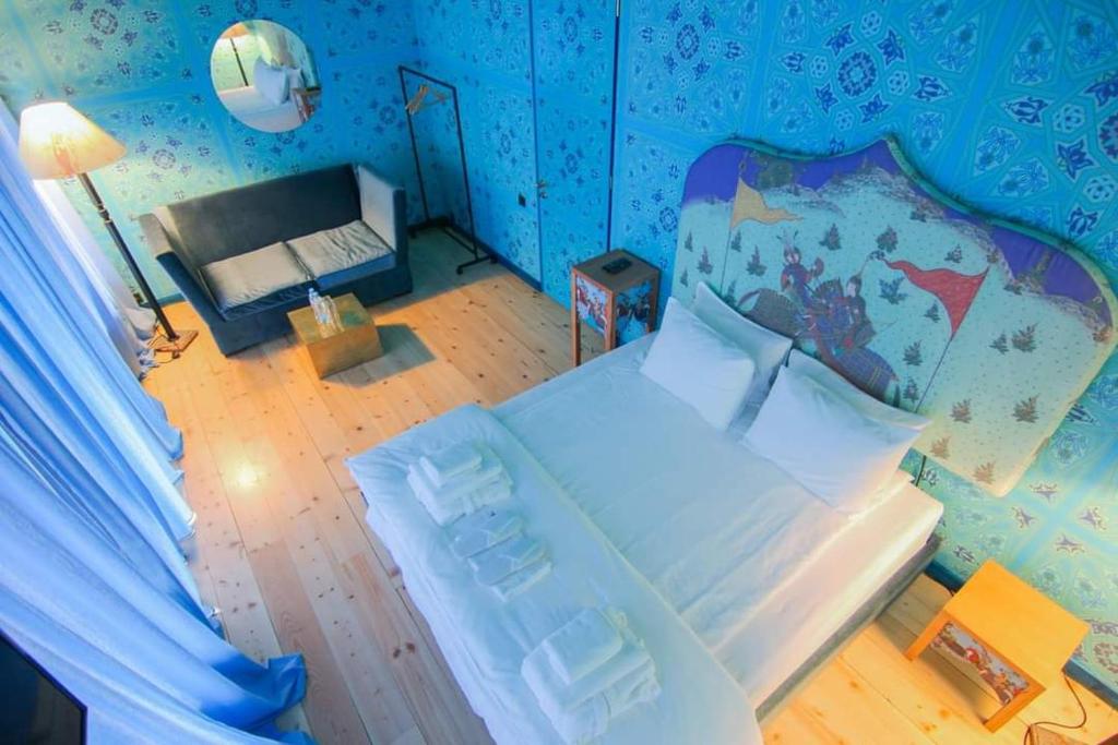 泰拉维Erekle II的一间设有一张大床的卧室,位于带蓝色墙壁的房间