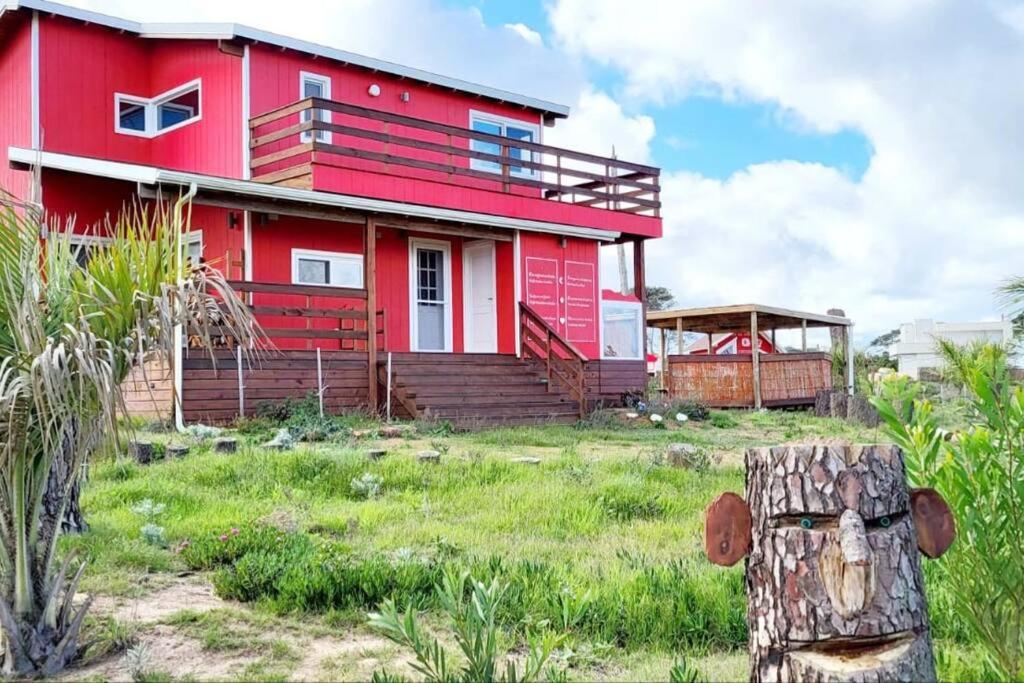 埃斯特角城Klimatisiertes Haus am Meer in Chihuahua的草场顶上的红色房子