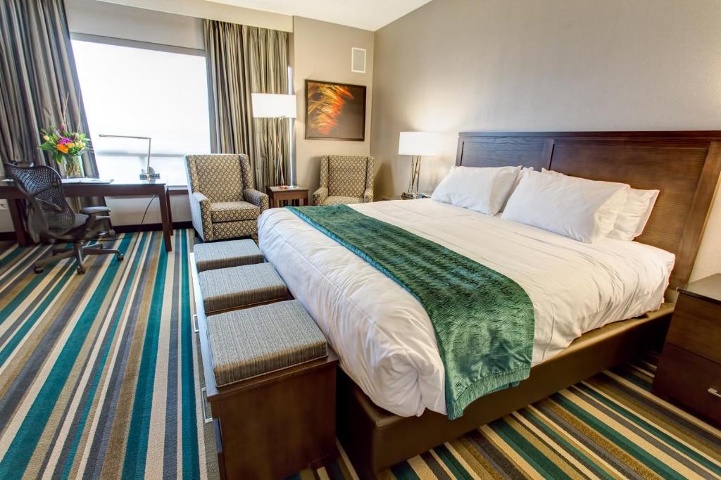 卡尔加里布莱克福特酒店的酒店客房设有一张大床和一张书桌。