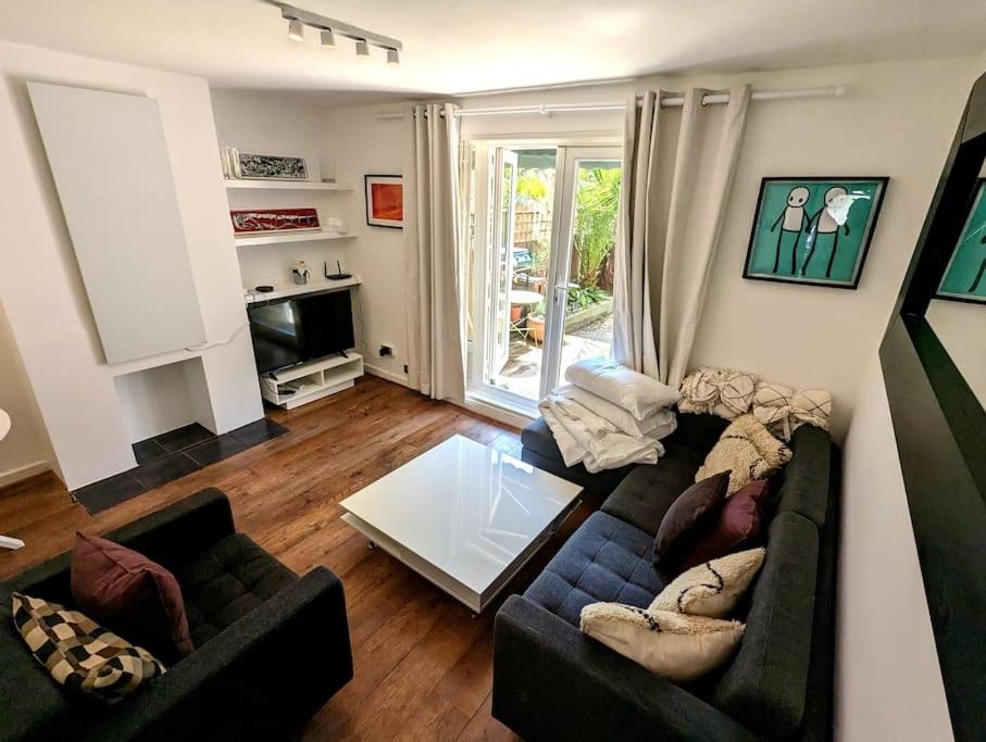 伦敦曼妙花园公寓的客厅配有两张沙发和一台电视机