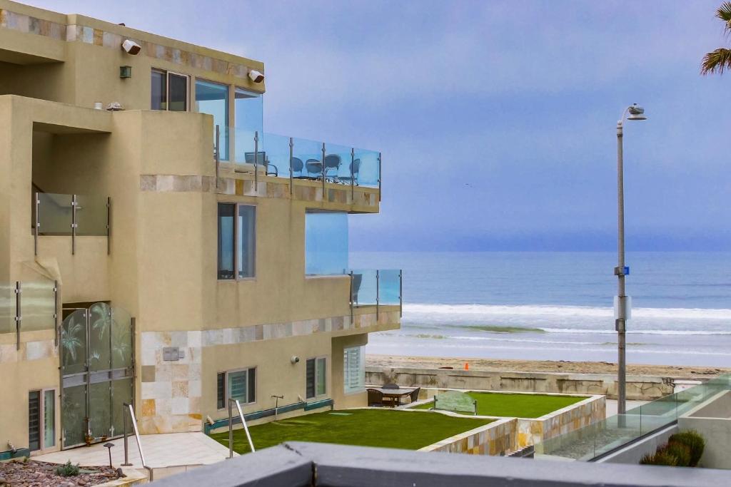 圣地亚哥OceanCatcher - newly remodeled 3 bedroom retreat with ocean view in the heart of Mission Beach, sleeps 10的带阳台的大楼,可俯瞰海滩