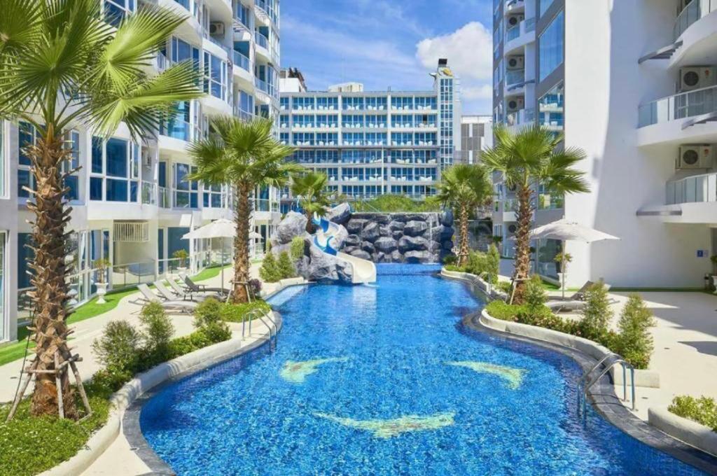 芭堤雅市中心Large Deluxe Condo Grand Avenue Central Pattaya的棕榈树度假村中心的一个游泳池