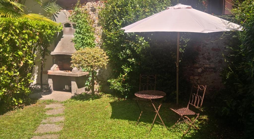安杰拉Residenza Esse的花园配有遮阳伞和桌椅