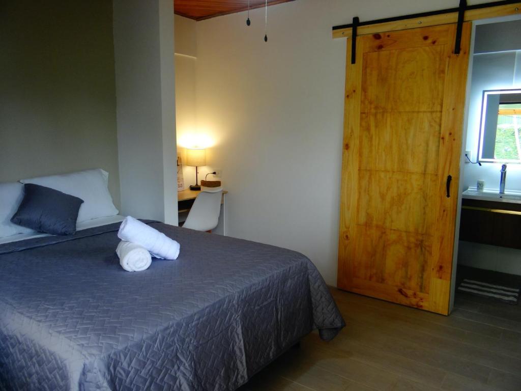 Santiago EsteAirport Green Studio的一间卧室配有一张床和一扇木门