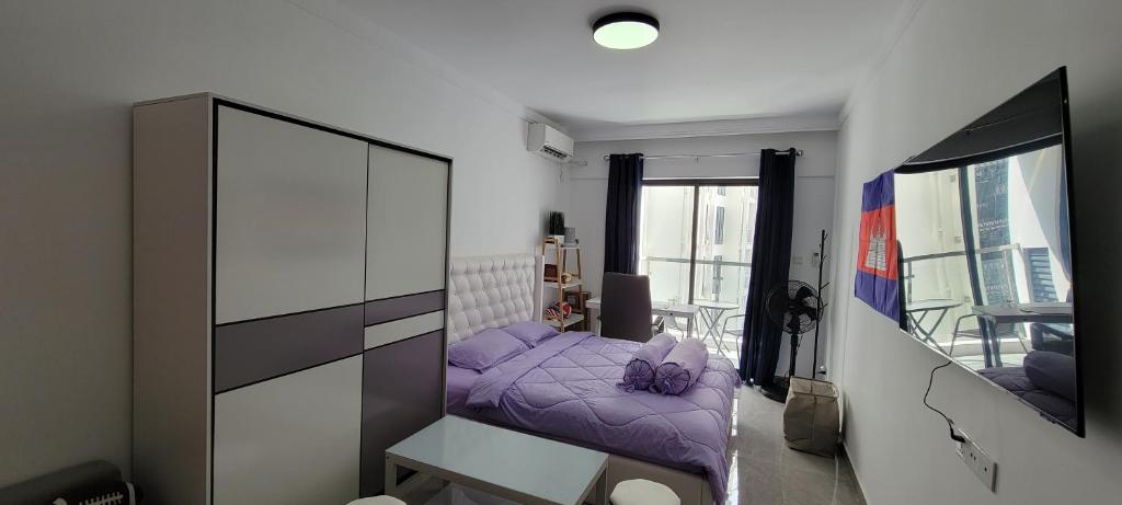 金边Cozy and Beautiful Condo on Riverside Phnom Penh的一间小卧室,配有一张紫色的床和镜子