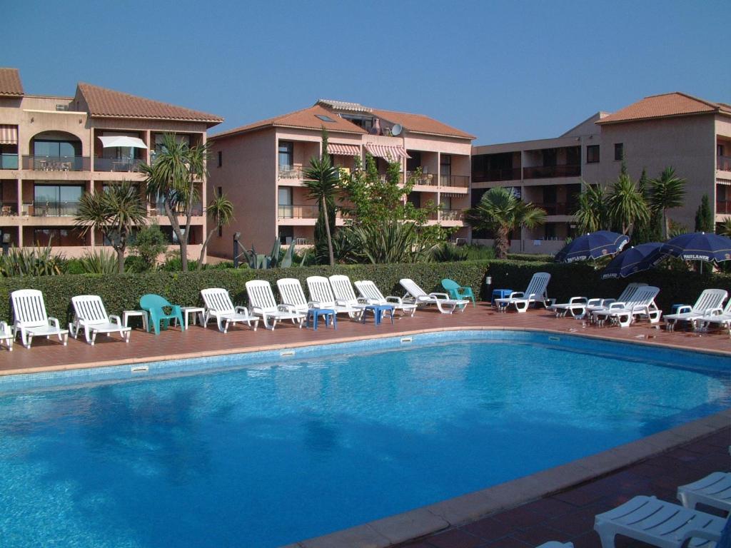 莫里亚尼海滩Résidence les Marines de Moriani Emeraude Locations的一个带躺椅的游泳池和一间酒店