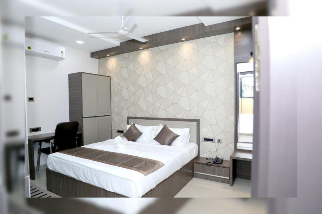 蒂鲁布尔HOTEL RSB PLAZA的一间卧室配有一张床、一张桌子和一张四柱床。
