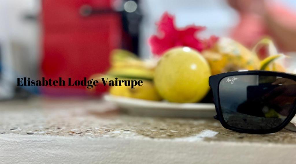 波拉波拉Elisabeth Lodge Vairupe的黑太阳镜,坐在一个有果盘的柜台上