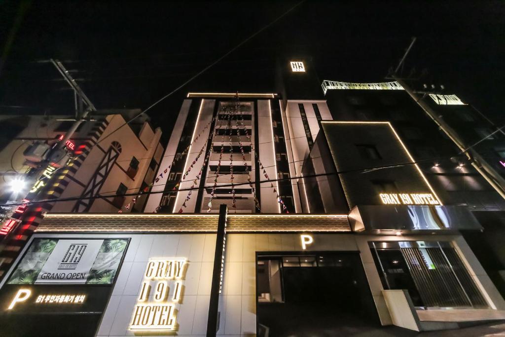 釜山Gray 191 Hotel的一座高大的建筑,晚上有标志